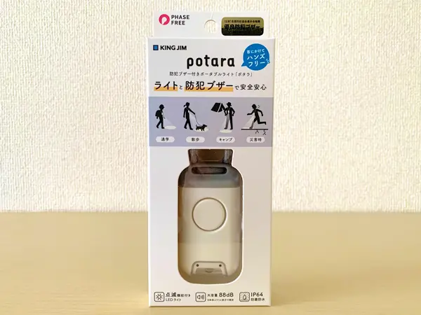 キングジムの防犯ブザー付きポータブルライト『ポタラ』の検証写真です。本体のパッケージを写した画像です。「ライトと防犯ブザーで安全安心」のキャッチフレーズがイラストとともに書いてあります。