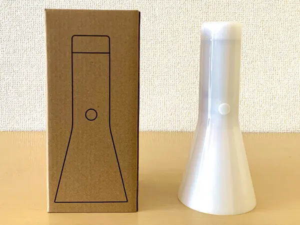 無印良品 『LED懐中電灯』の検証写真です。製品のパッケージと製品を並べて撮影された画像です。無印良品のシンプルなパッケージが印象的です。段ボール地に黒いラインでLED懐中電灯のイラストが描かれています。