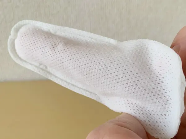 無印良品『指型歯みがきシート』の検証写真です。実際に中のシートを出して、右手の人差し指にはめてみた画像です。大人の男性の指でも余裕があって、はめることができています。