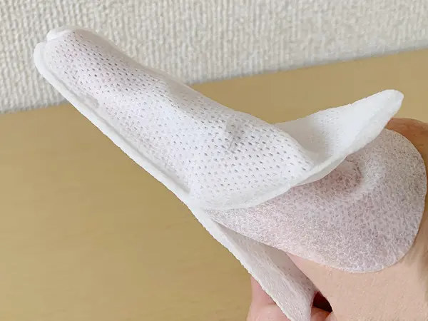 無印良品『指型歯みがきシート』の検証写真です。実際に中のシートを出して、右手の人差し指にはめてみた画像です。シートは両サイドが二層構造になっていて、歯みがき中に抜けてしまうのを防ぐ役割があります。