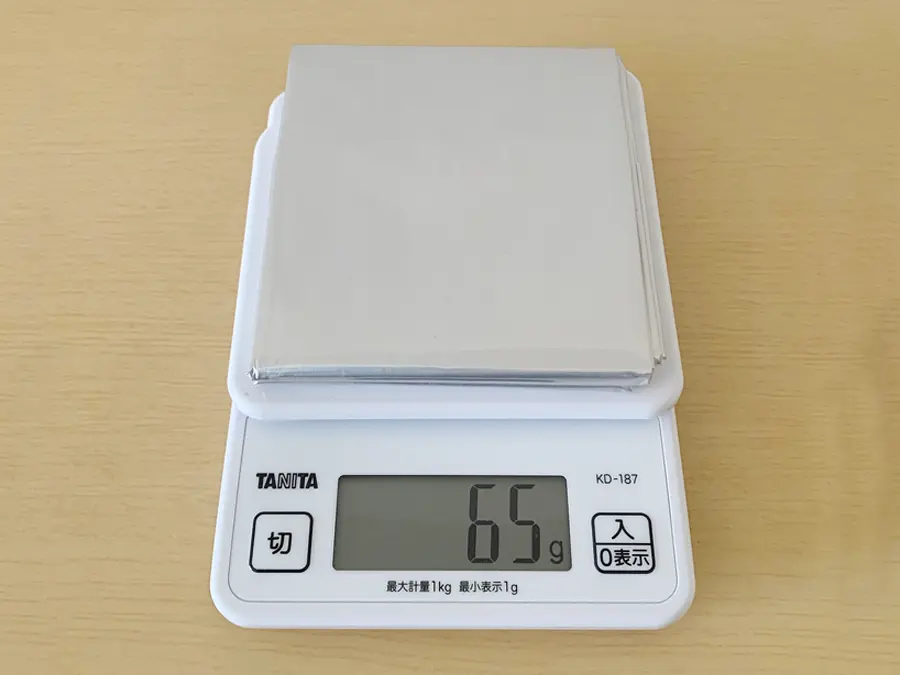 無印良品『エマージェンシーシート』の検証写真です。重さを測っている画像です。重さはシート単体で65グラム。非常時、災害時には、かさばらず、重くないことも携帯する上で大切なことです。