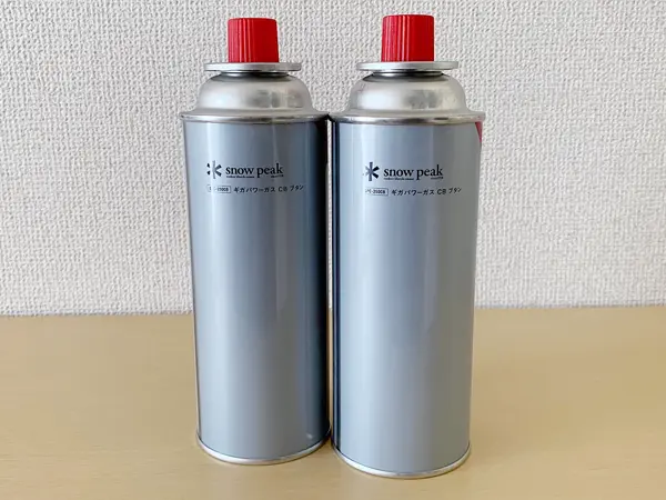 スノーピークから販売されている『Home & Campバーナー』の検証写真です。スノーピークから発売されているオリジナルの専用ガスの画像です。全体がグレーでシンプルにロゴが入っている、とてもシンプルなデザインでスノーピークらしいこだわりがここでも感じることができます。